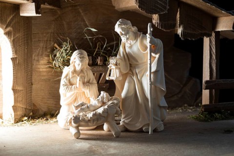 The Holy Family at the crib, wooden crib figurines represent the birth of Jesus Christ Child lying