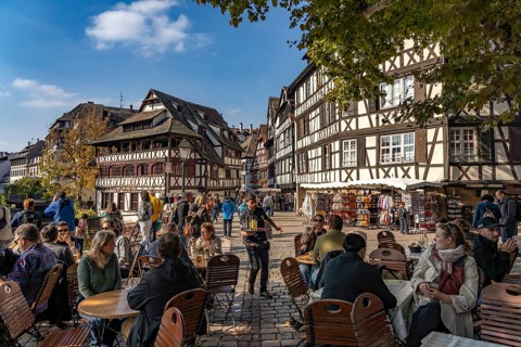 Busy cafe on Place Benjamin Zix and the Maison des Tanneurs timber-frame house in Petite France,