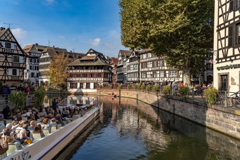 Sightseeing boat, half-timbered houses and the Maison des Tanneurs on the river Ill in Petite