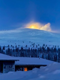Snow sweeps over the fells in front of the moon at twilight, Hotel Pallas, Pallas-Yllästunturi