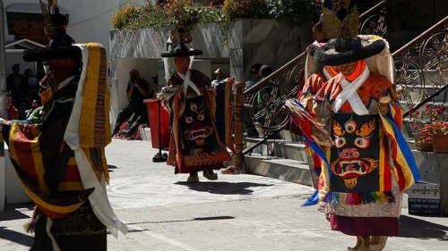 People in traditional costumes dance outside at a cultural event in Leh, trekking in Ladakh,