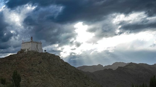 Small monastery on a mountain under dramatic cloudy sky, Leh, trekking in Ladakh, Stok la,