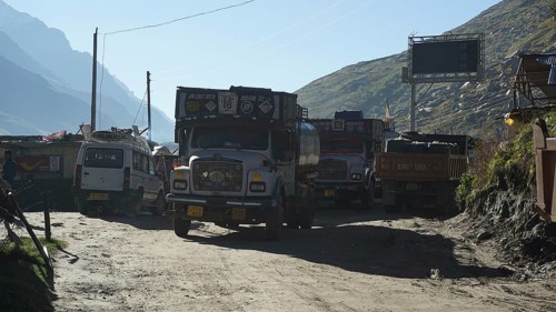 Several trucks on a mountain road in a small village in sunny weather on the Manali-Leh Highway,