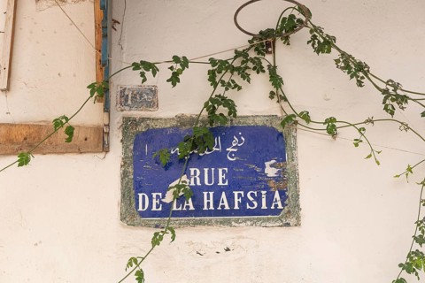 A Tunisian street sign for Rue de la Hafsia written in French and Arabic in the main thoroughfare