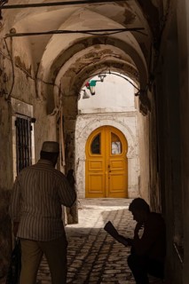Tunis, Tunisia. 13th May 2024 A dark narrow alley with a bright yellow door, a traditional scene in