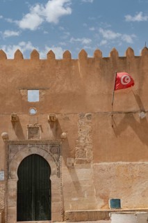 The Tunisian national flag flying from inside the ancient city walls of the medieval medina of Sfax