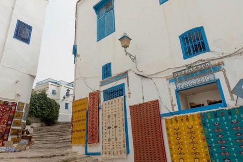 May 17th 2024. Sidi Bou Said, Tunisia. Tourist souvenir rugs hanging outside a store in the narrow