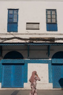 Tunis, Tunisia. 4th May 2024 A Muslim using a cell phone walks past traditional blue coloured