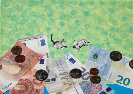 Bull terrier and Dalmatian miniature figure standing on green background with euro coins and notes,
