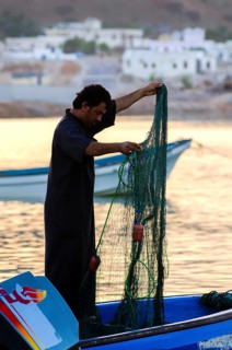 Tiwi, Oman. May 26th 2014. Silhouette of Omani fishermen at sunset in the fishing village of Tiwi