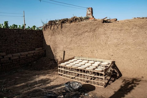 Freshly made dough to make traditional bread drying in the sun outside a typical mud brick house in