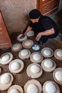 Luxor, Egypt. 13th December 2020 An Egyptian woman preparing dough to make bread in a Nile side