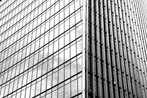 Modern black and white graphic image of abstract reflections in glass fronted commercial office