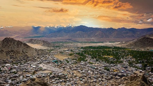 Extensive panoramic view of Leh with snowy mountains in the background under a colorful sky, Leh,