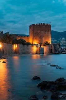 Beautiful evening view of Alanya Harbour and the Red Tower with the Taurus Mountains and