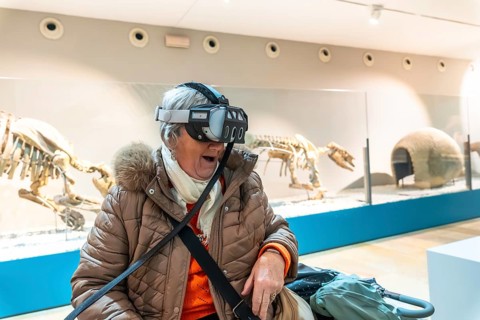 Senior woman wearing a vr headset with an open mouthed, delighted expression experiencing immersive