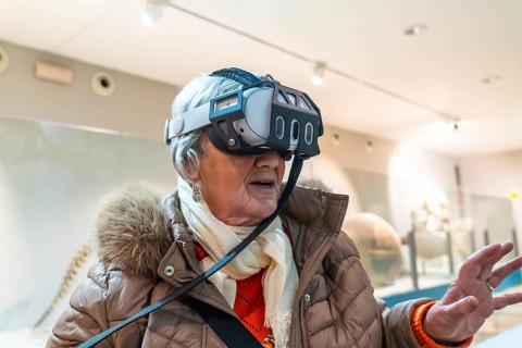 Senior woman wearing a vr headset, exploring immersive digital content and interactive exhibits in