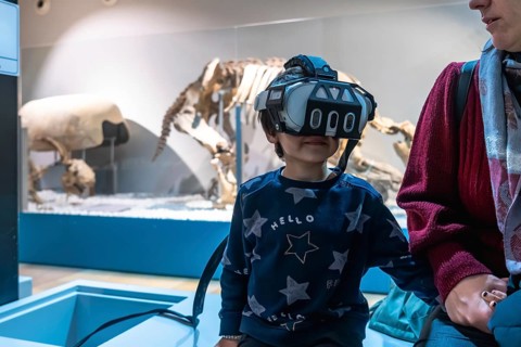 Young boy wearing a modern vr headset. Experiencing an immersive educational simulation at a museum