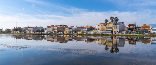 Traditional houses of el palmar fishing village reflecting perfectly on the calm water surface of