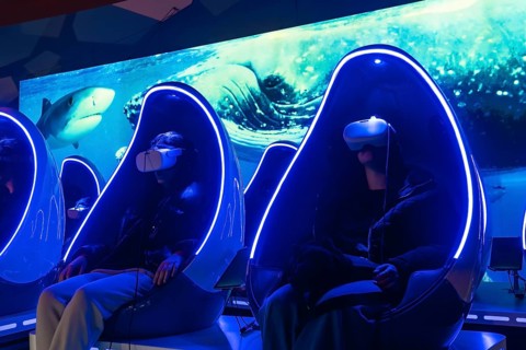 People wearing virtual reality headsets enjoying an immersive deep sea experience while sitting in