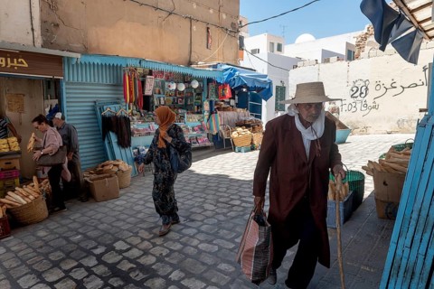 Male and female Tunisians shopping for bread in the market of Sfax Medina, Tunisia, North Africa