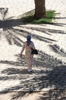 A Tunisian muslim wearing a patterned dress women walks in the streets of Sfax, the second largest