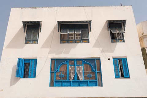 Classic white washed walls and blue painted windows of Tunisian architecture in the UNESCO world
