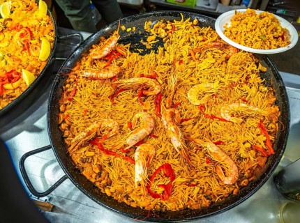 Large paella pan presenting fideua, a traditional spanish noodle dish from valencia, prepared with