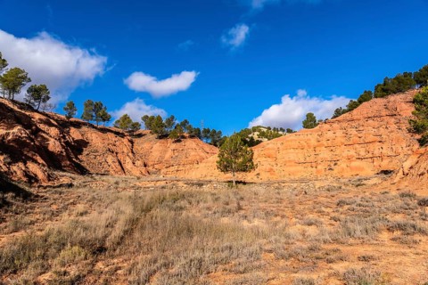 Las arcillas natural park in teruel shows vivid red clay badlands and eroded canyons topped with