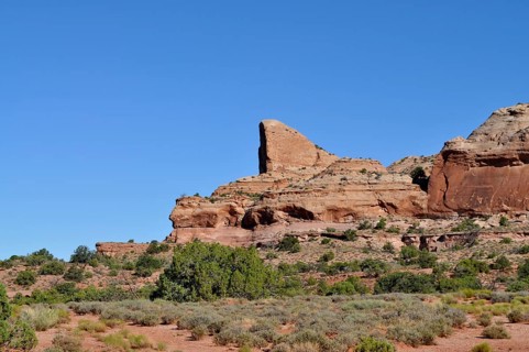 Large, towering rock in a sparsely vegetated desert landscape, Canyonlands National Park, Island in