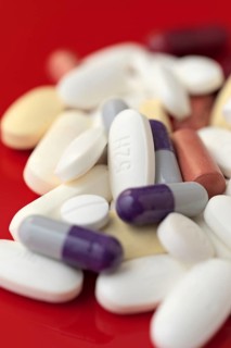 A close-up image showcasing a variety of medical pills and capsules in white, purple, and red