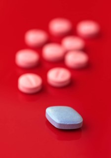 A vivid image showcasing a blue pill prominently in focus with several pink pills in the