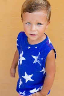 A young boy with blue eyes gazes upwards, wearing a blue shirt with white star patterns His