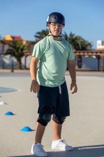 Teenage boy with Down syndrome enjoying outdoor sports activities, wearing safety equipment