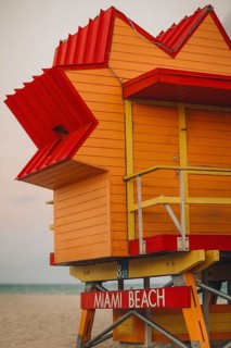 A vibrant, colorful lifeguard stand at Miami Beach, featuring a bold red and yellow color scheme