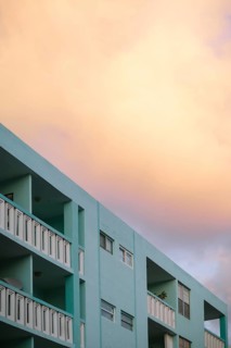 Soft sunset colors bathe a Miami Beach building, rendering the sky in warm peach tones above the