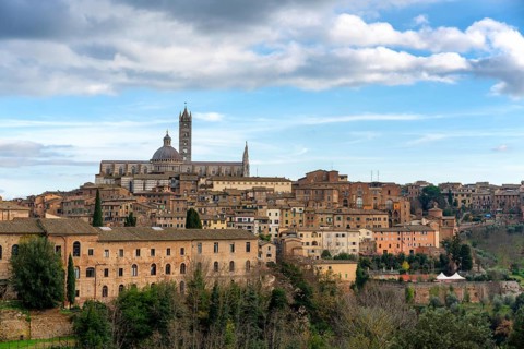 A scenic view of Siena, Italy, featuring its historic architecture, the iconic Siena Cathedral, and