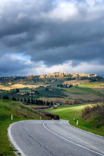 A scenic view of Pienza from the main road in Val d Orcia, Tuscany. The winding road cuts through
