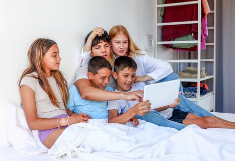 Five siblings, including a young teen woman, a young man, and triplet kids (a girl and two boys),