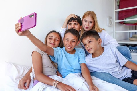 A teenage girl and young man with blond hair and lighter skin, likely older siblings, join a girl