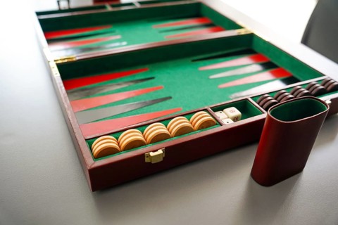A detailed shot of a backgammon board, highlighting the checker pieces and dice inside a classic