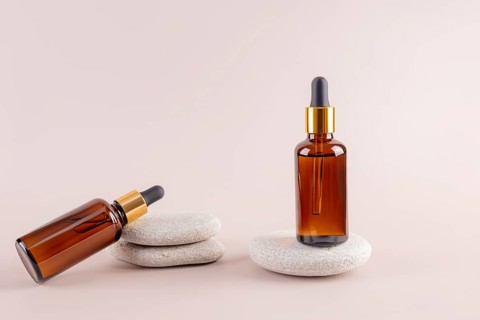 Two amber glass dropper bottles on smooth stones, featuring a minimalist aesthetic Ideal for