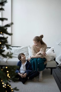 A warm holiday moment, a mother and child share smiles in a cozy living room with festive decor A