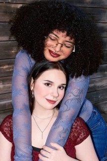 Two multiethnic Gen Z women sharing a close embrace, displaying friendship and joy. The Hispanic