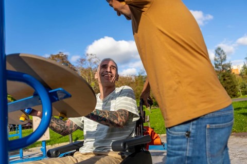 Friends enjoy a sunny day in the park, focusing on inclusive fitness for cerebral palsy One is