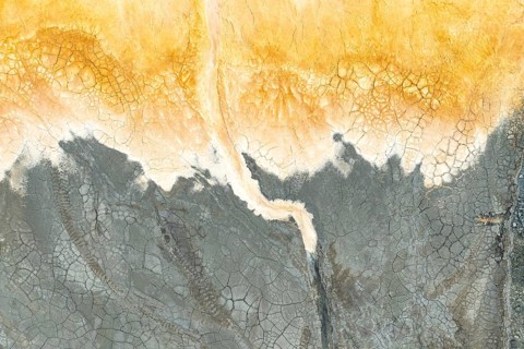 Captivating multicolored mud texture showcasing vibrant orange and gray hues The cracked surface