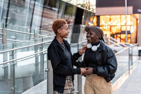 Happy LGBT multiethnic couple enjoying a cheerful moment outdoors in the city during sunset,