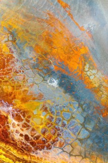 Vivid multicolored mud texture showcasing an abstract pattern A blend of earthy tones like orange,