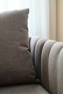 Close-up of a plush pillow on a stylish sofa, embodying modern luxury and elegance. The soft fabric