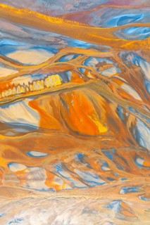 A striking multicolor abstract texture showcasing dynamic flowing patterns in vivid orange, blue,